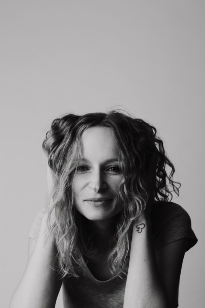 Frau rafft sich die Harre am Kopf und lacht